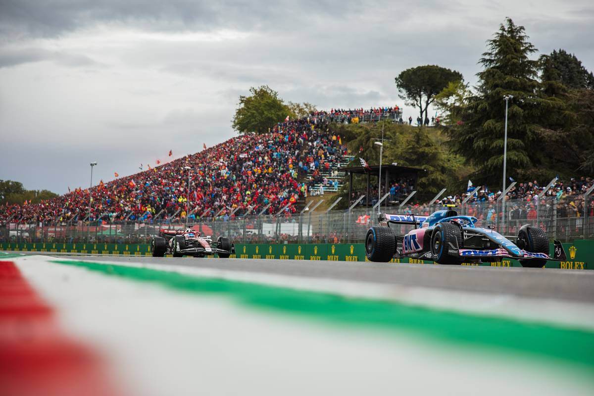 Voiture de course formule 1 roule sur une route marquée d'un drapeau aux couleurs de l'italie