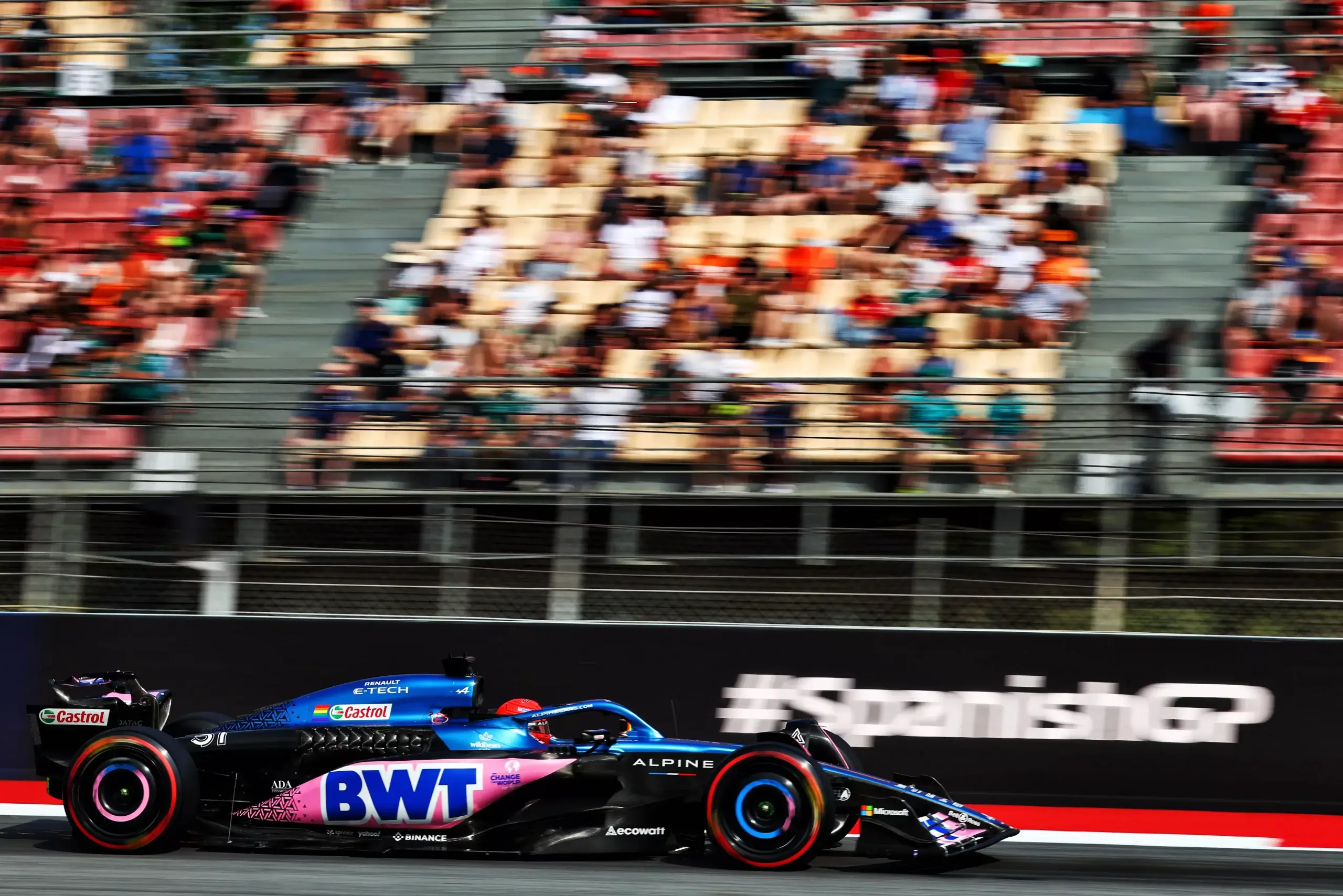 Une voiture de formule 1 passe à toute vitesse devant une tribune à moitié vide