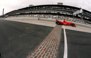 Une voiture formule 1 rouge Ferrari passe la ligne d'arrivée mythique en pavé d'Indianapolis